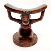 Wooden headrest with a base in the shape of a kneeling woman