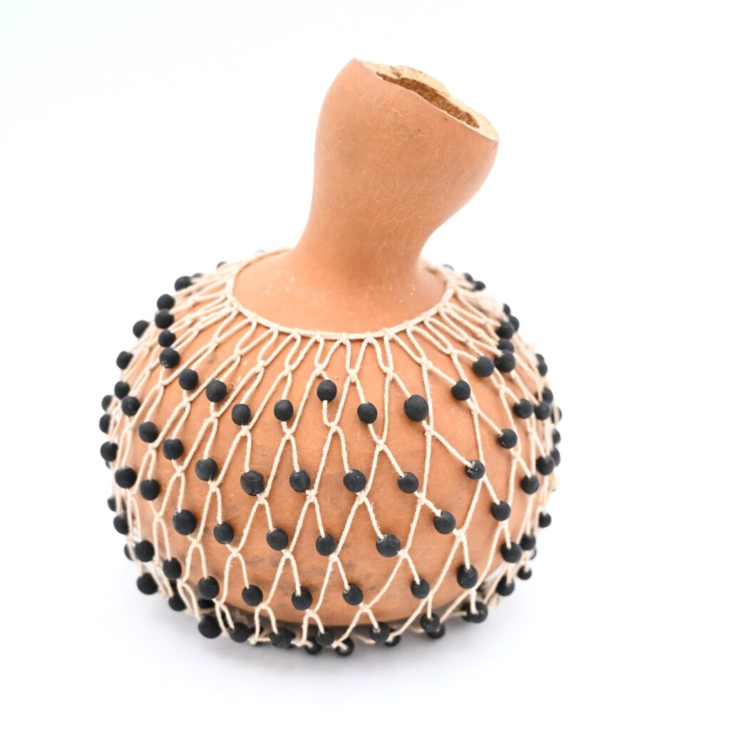 Dried gourd surrounded by netting with seed beads attached
