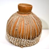 large gourd with strings around it and cowrie shells around the bottom portion