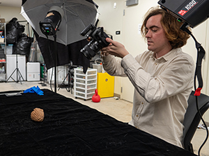 A man taking a photo of a ceramic head